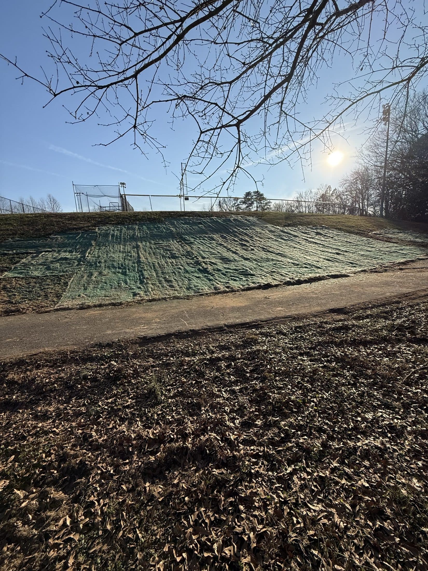 Erosion control matting installed across the regraded slope above the new concrete work