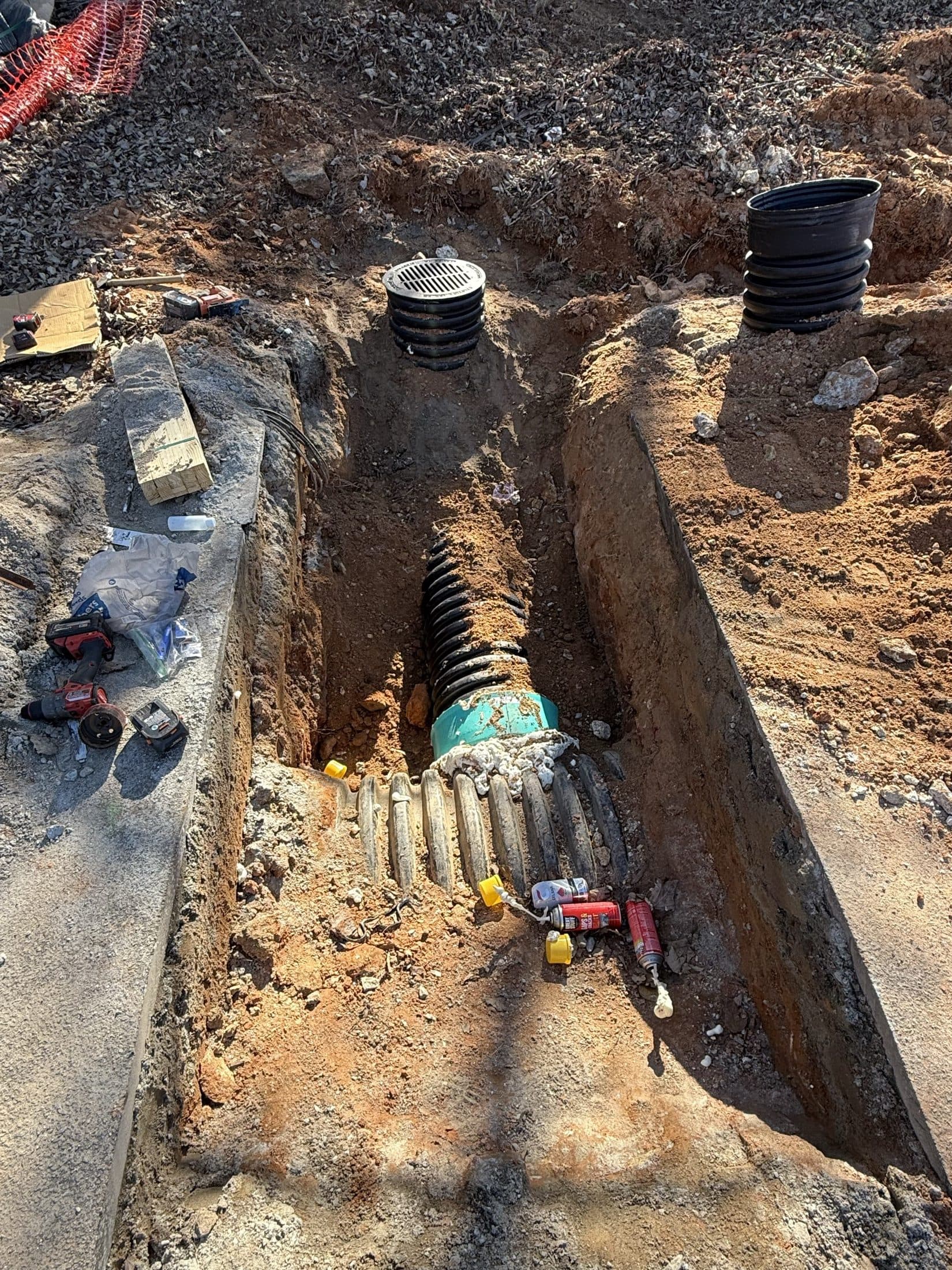 Storm pipe and basin structures set in the open trench before backfill