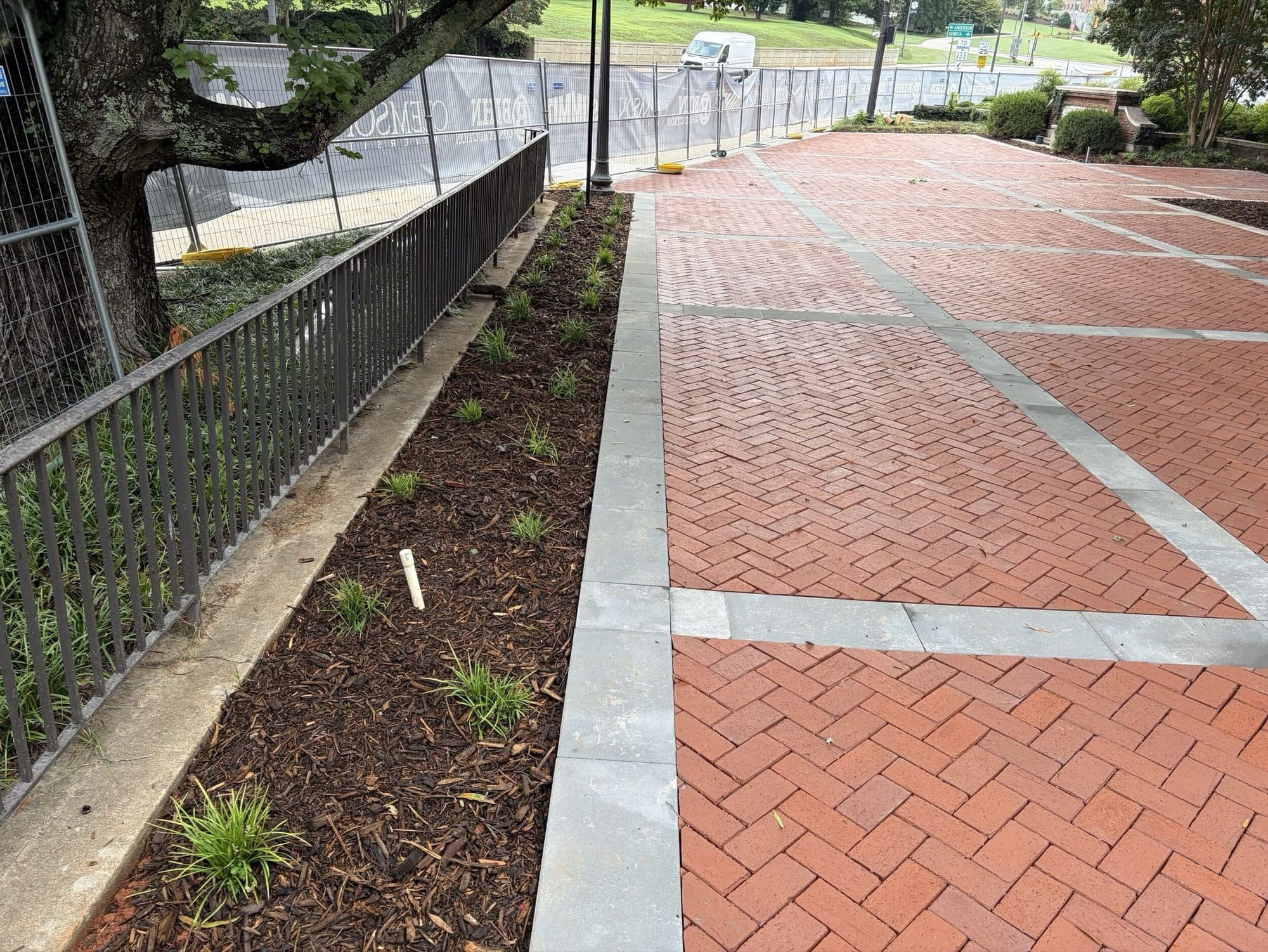 The finished accessible ramp beside the plaza, with new planting beds and concrete banding