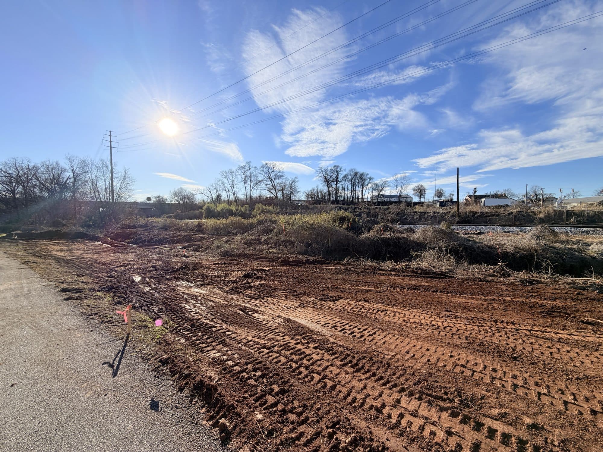 Track marks across the freshly graded creek corridor during earthwork