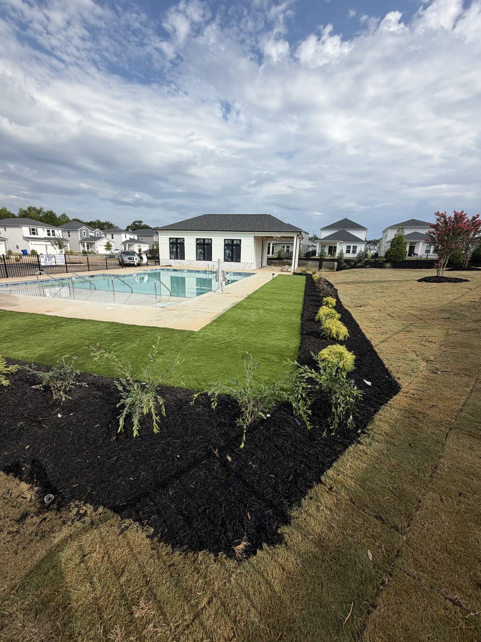 Aerial view of the finished clubhouse, pool, and fenced amenity lawn set among the Gramercy Woods homes