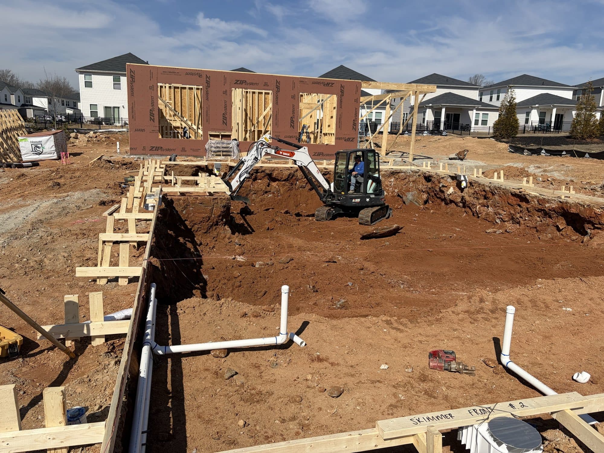 Underground plumbing run and braced against the formed foundation edge before backfill