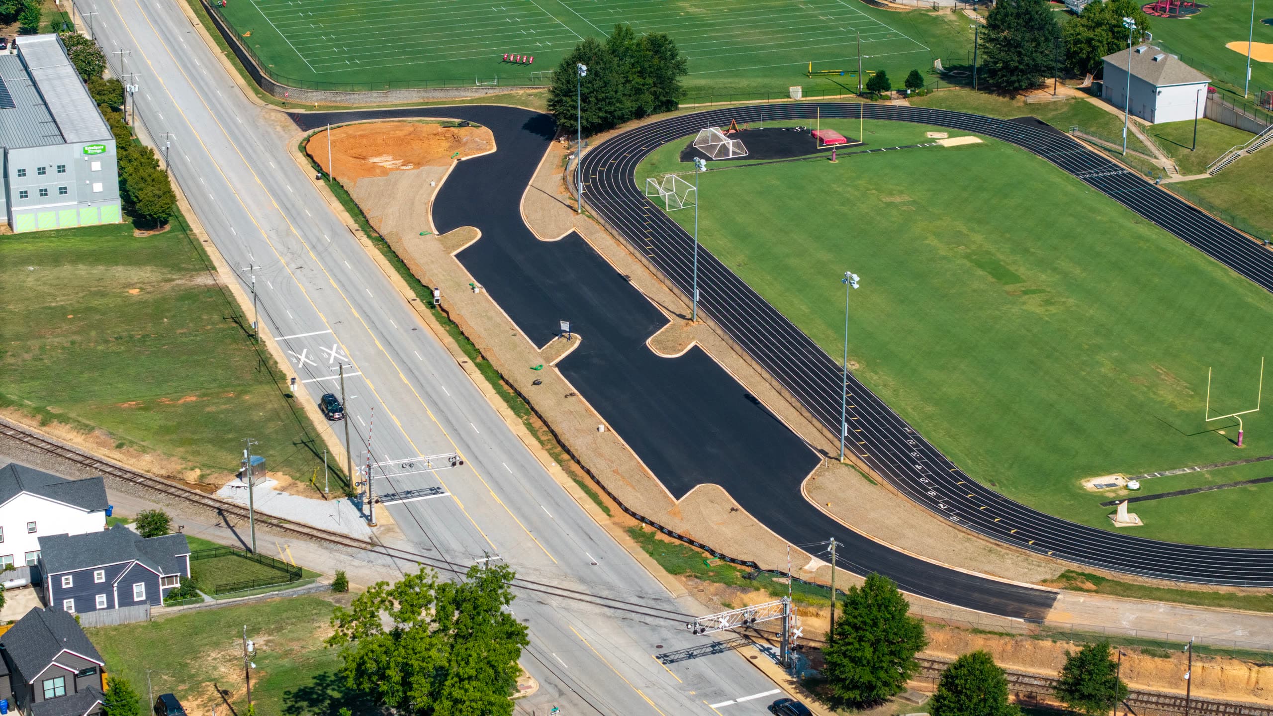 The finished asphalt lot alongside the Edward P. Holder, Jr. Track and Field, with curbed islands and access drives cut in