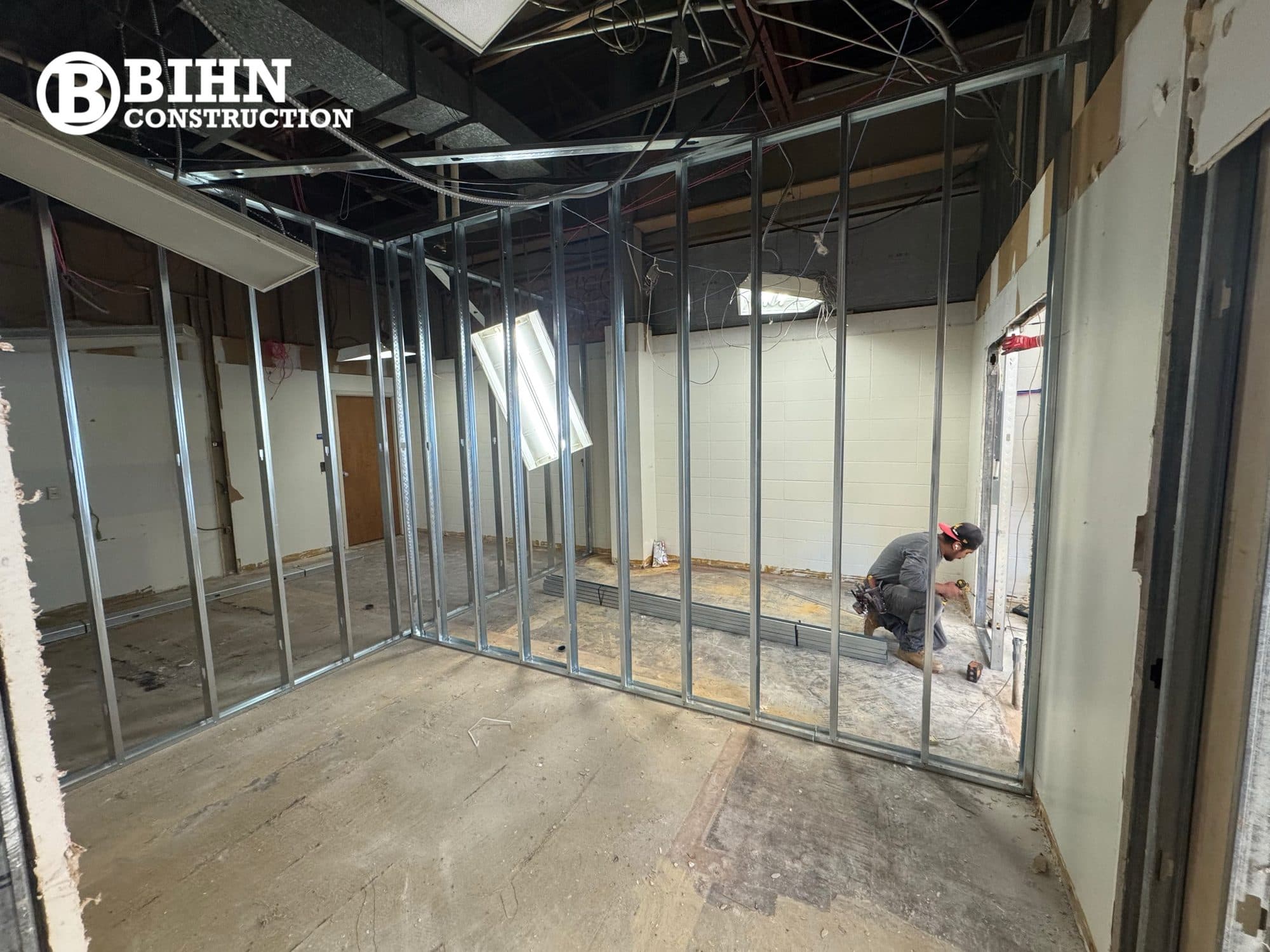 The office suite in bare metal stud framing, with the ceiling stripped back to structure