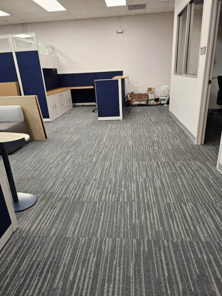 The same suite finished and in use, with carpet tile, casework, and blue workstation partitions